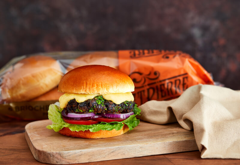 Autumn Burger Recipe Ideas: a vegetarian burger on a wooden board next to a tea towel