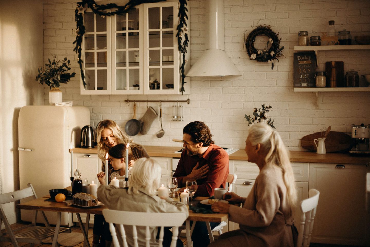 christmasfamilymealsmain A family sat at a dining table in a kitchen enjoying food and drink