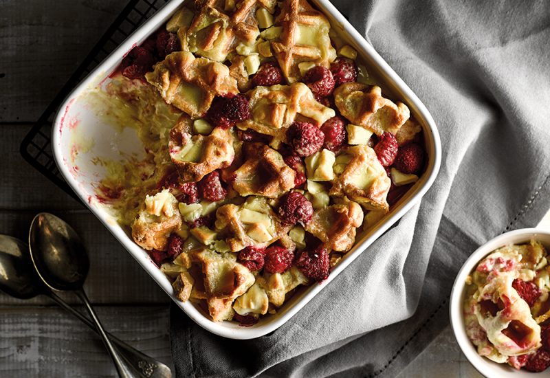 sp_web__0000_white_chocolate_and_raspberry_waffle_pudding_cmyk_small An overhead photo of a waffle and fruit bake in a big ovenproof dish