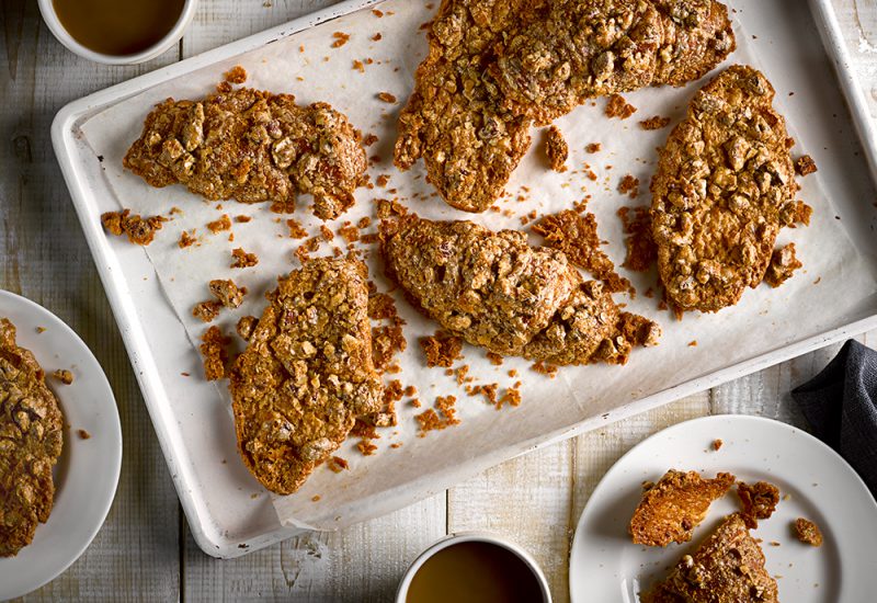 sp_web_productshots_2_0013_ukbuttercroissantbrittlere Sliced croissants on a baking tray covered with peanut butter and caramel pieces