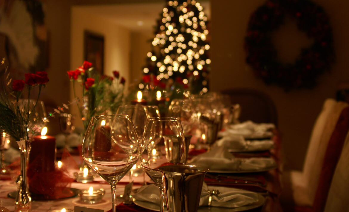 A Christmas table setting with glassware, cutlery and decorations